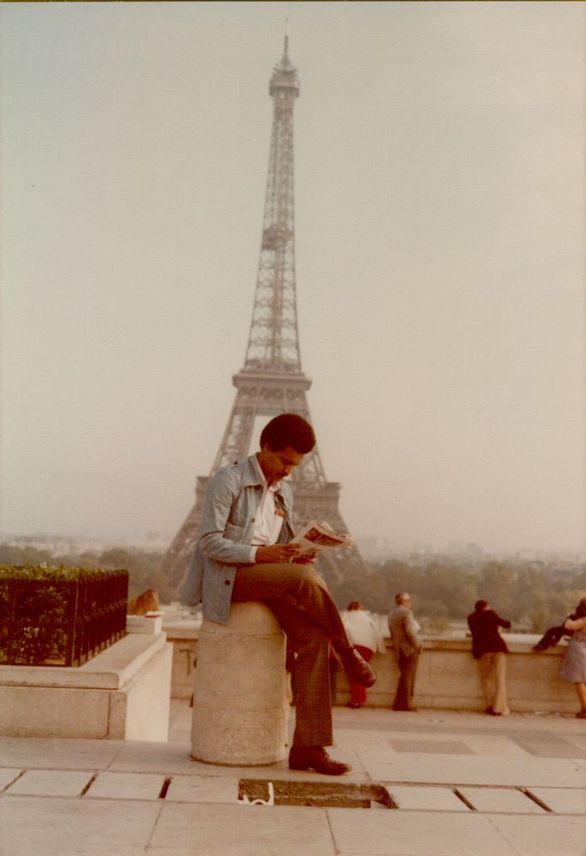 Amha reading at the Trocadéro with the Eiffel Tower behind him