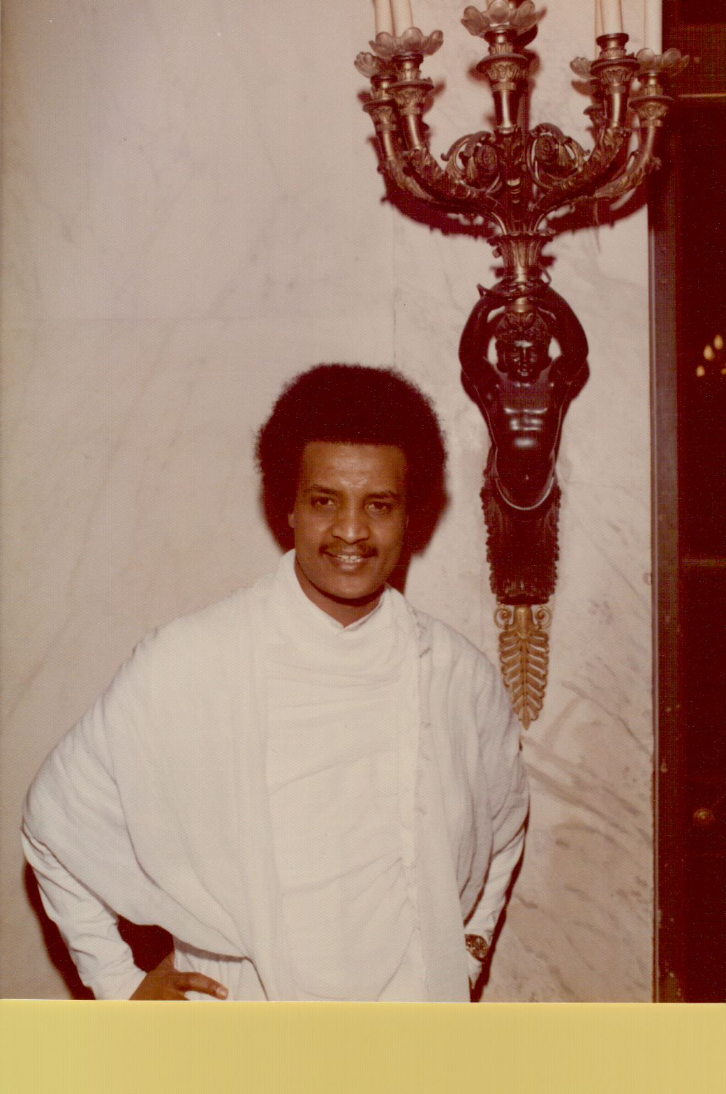 Amha in traditional Ethiopian dress in a grand marble interior