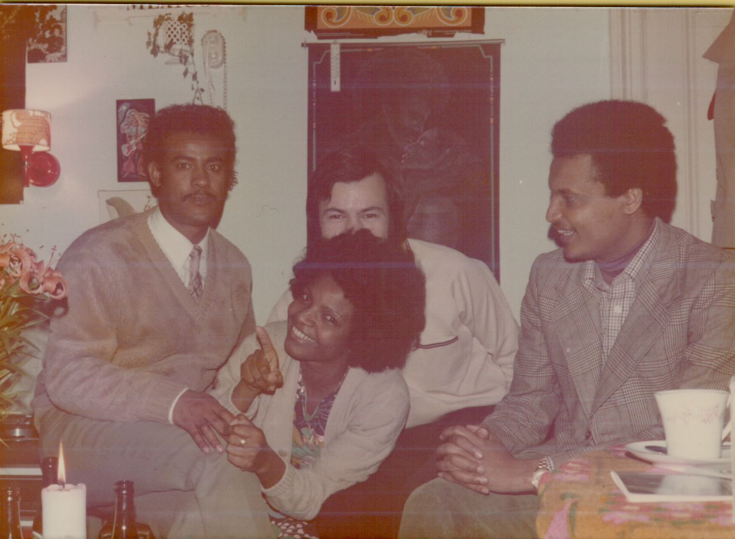 Friends gathered in a living room with Ethiopian art on the wall