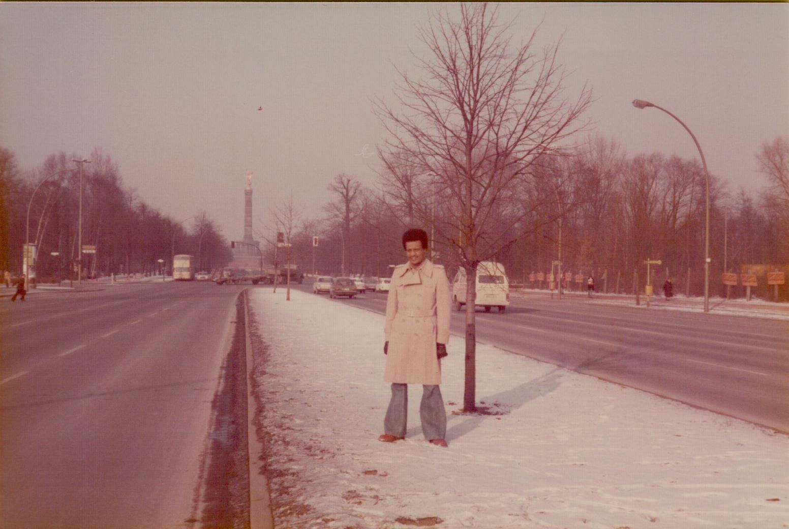 Amha standing on a snowy Berlin boulevard with the Victory Column in the background