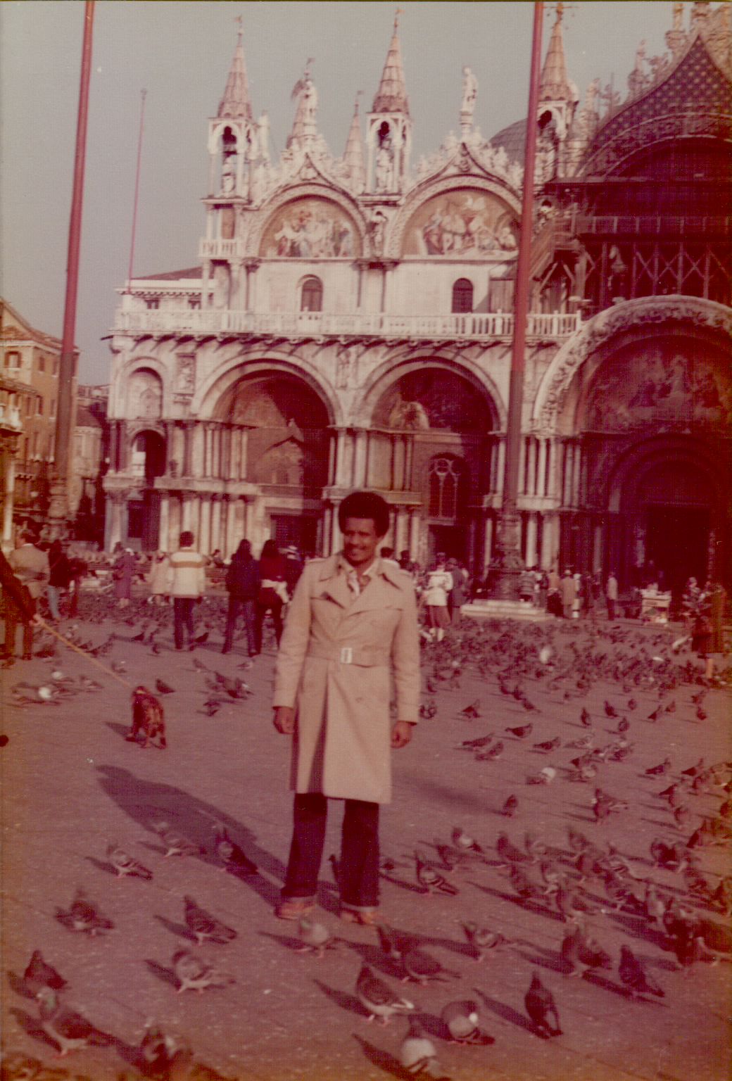 Amha standing in St. Mark's Square, Venice, surrounded by pigeons